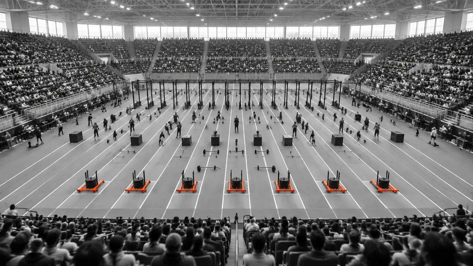 Large crowd in an indoor arena watching a fitness race