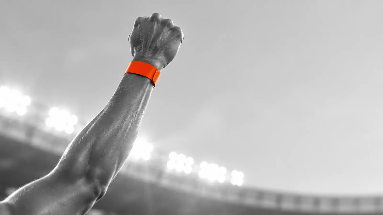 Athlete holding up their race wristband with a smile